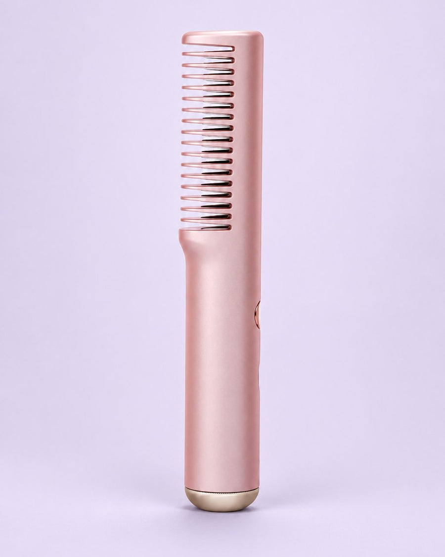 Pink cordless straightening comb with its single row of heated teeth
