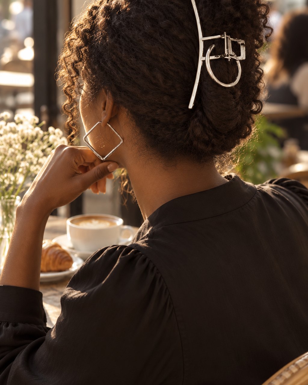Woman in a black top with her hair clipped up in the silver claw clip