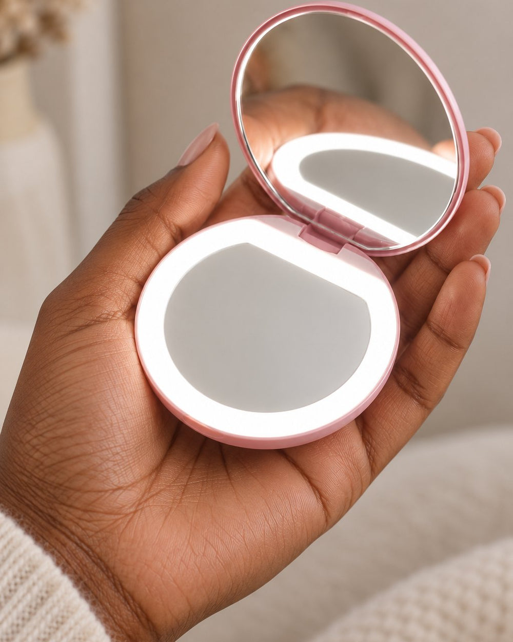 The open compact held in one palm, glowing softly
