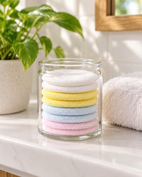 Stack of reusable rounds in a glass jar on a bathroom shelf