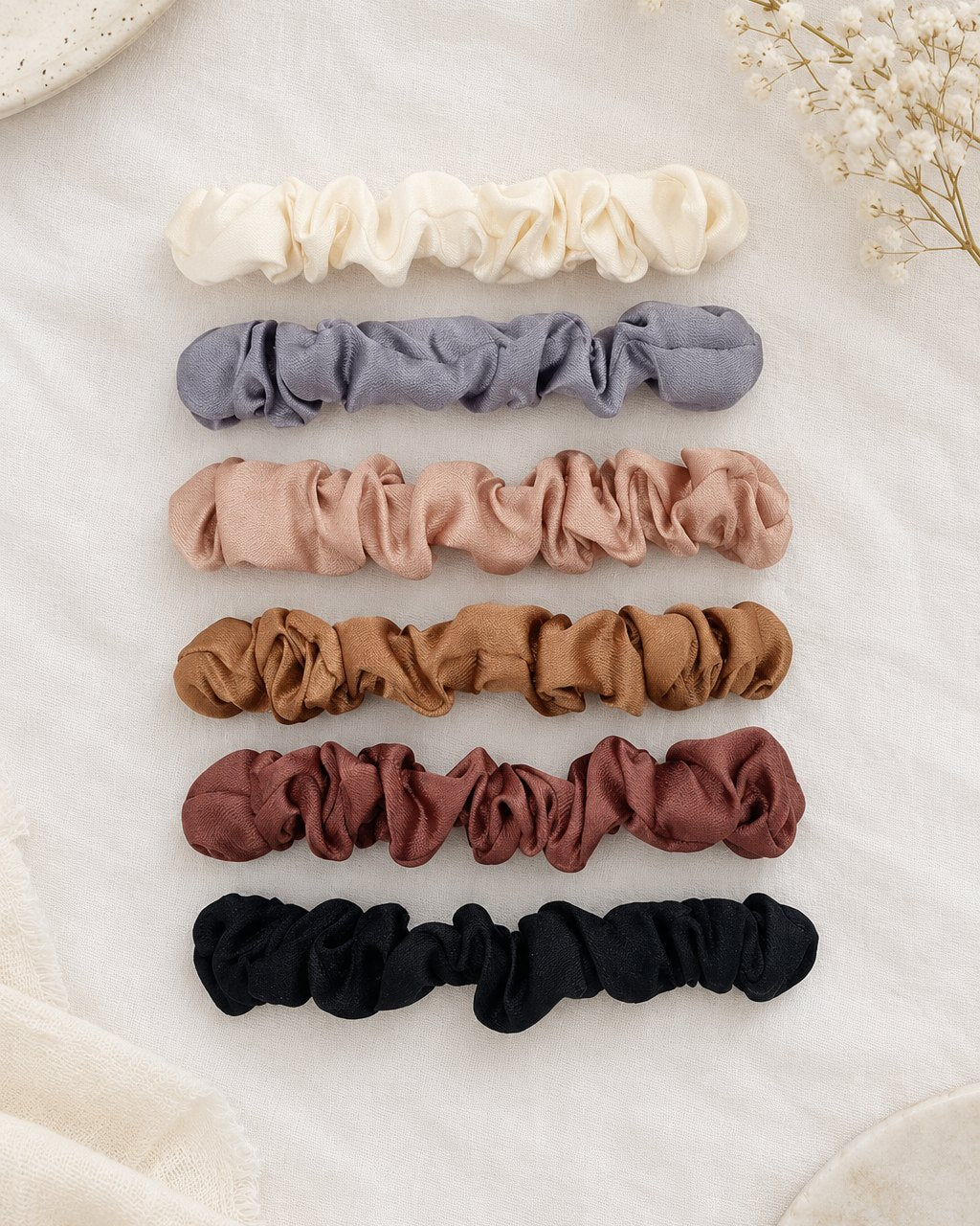 All six scrunchies laid out in a neat row by colour