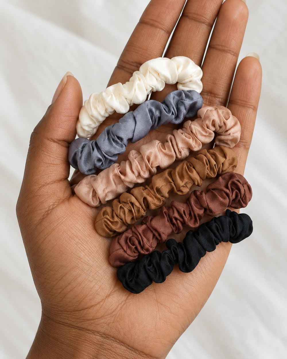 The six scrunchies held loosely in one hand