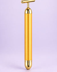 Gold-tone vibrating beauty bar with a T-shaped head, standing